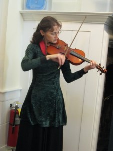 A fiddler strolled up and down the aisles, entertaining us with her music. (Name TK.)