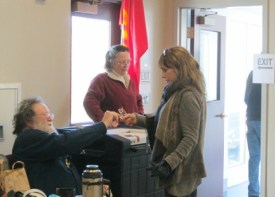 Constable Tim Maley hands voter an "I Voted" sticker.