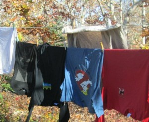 T-shirt close-up. Note blue Trumpbusters T at center and "I'm With Her" arrow on the left.